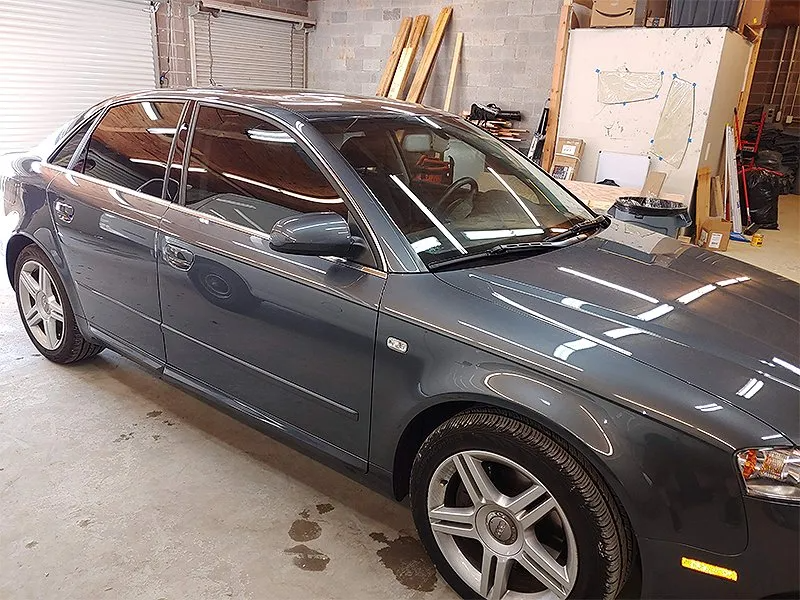 Gray Audi sedan in a garage, tinted windows, parked.