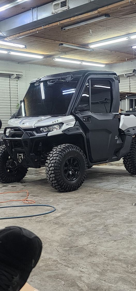 Black UTV with black wheels in a garage.
