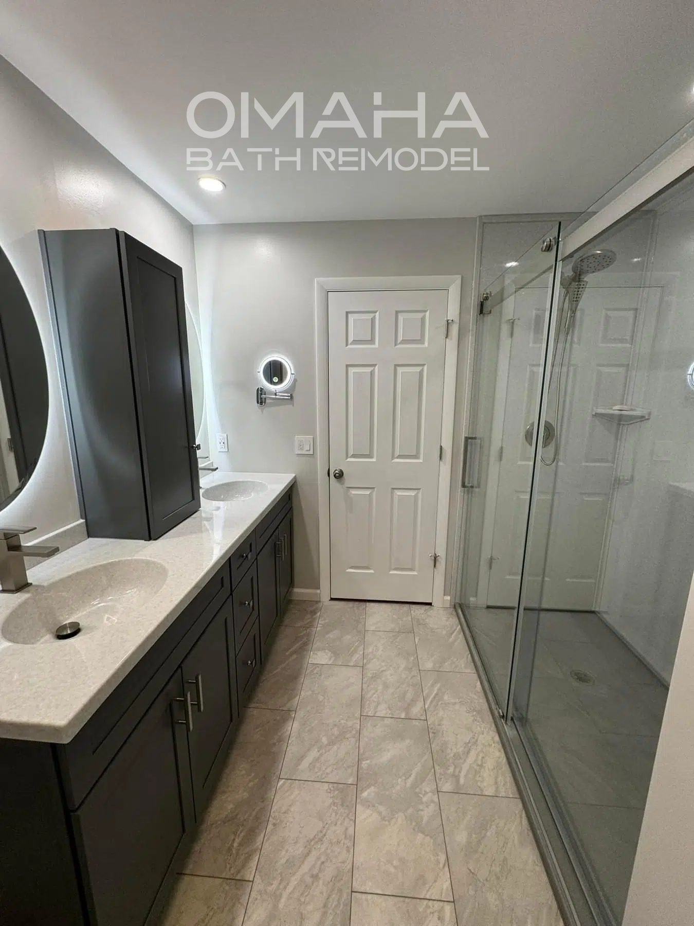 A bathroom with two sinks and a walk in shower.