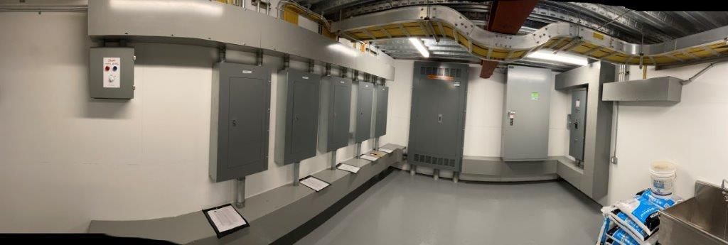Electrical room with gray electrical panels and conduit.