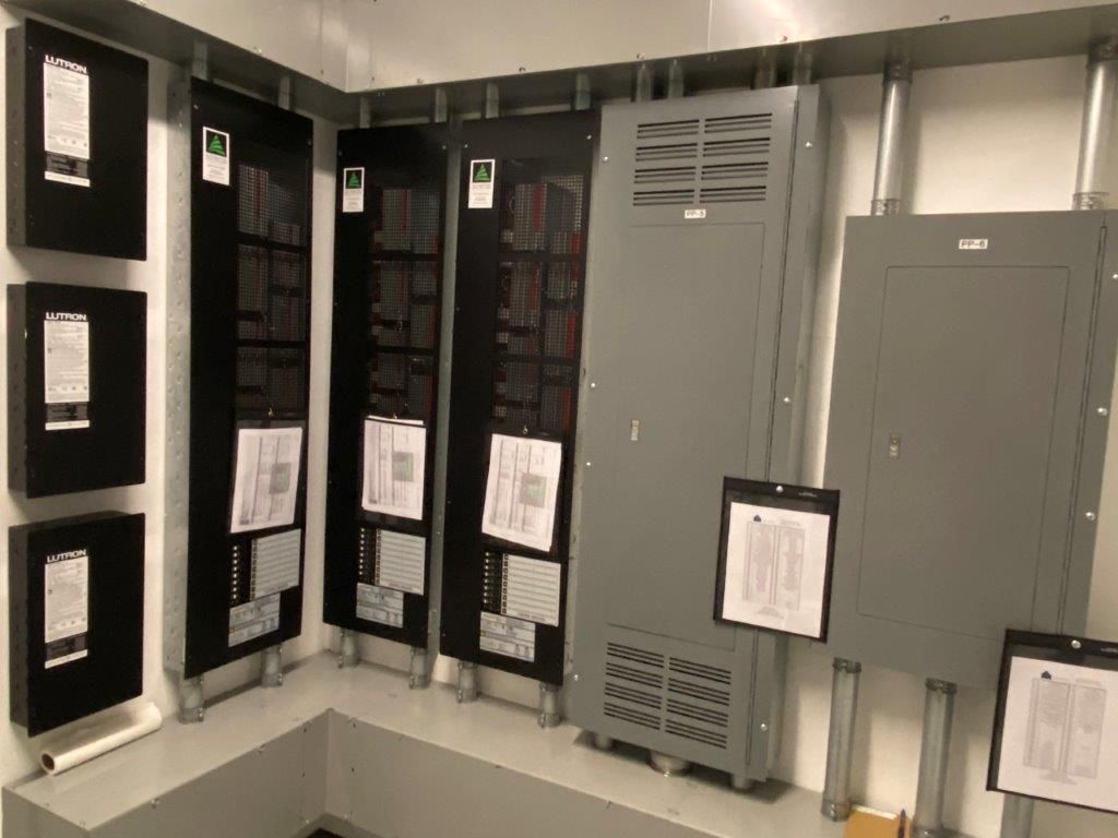 Electrical panel room with black and gray panels, mounted to the walls.