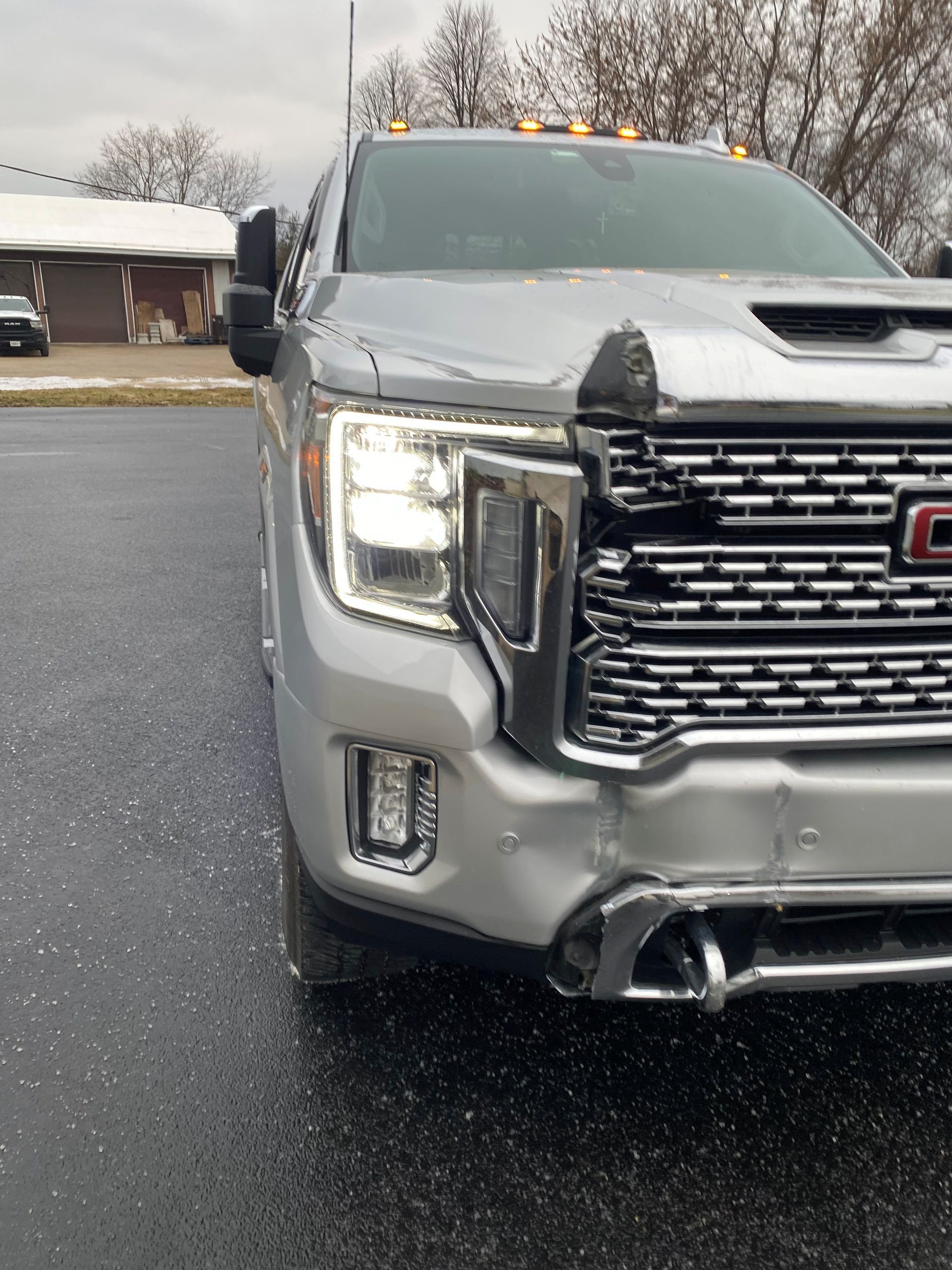 White pickup truck, rear view, in a shop, black tire, silver wheel, black bed cover, and red tail light - before