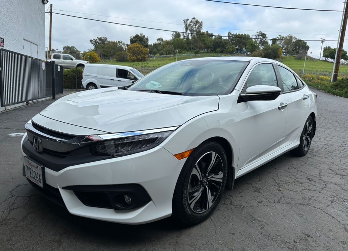 A white honda civic is parked in a parking lot.