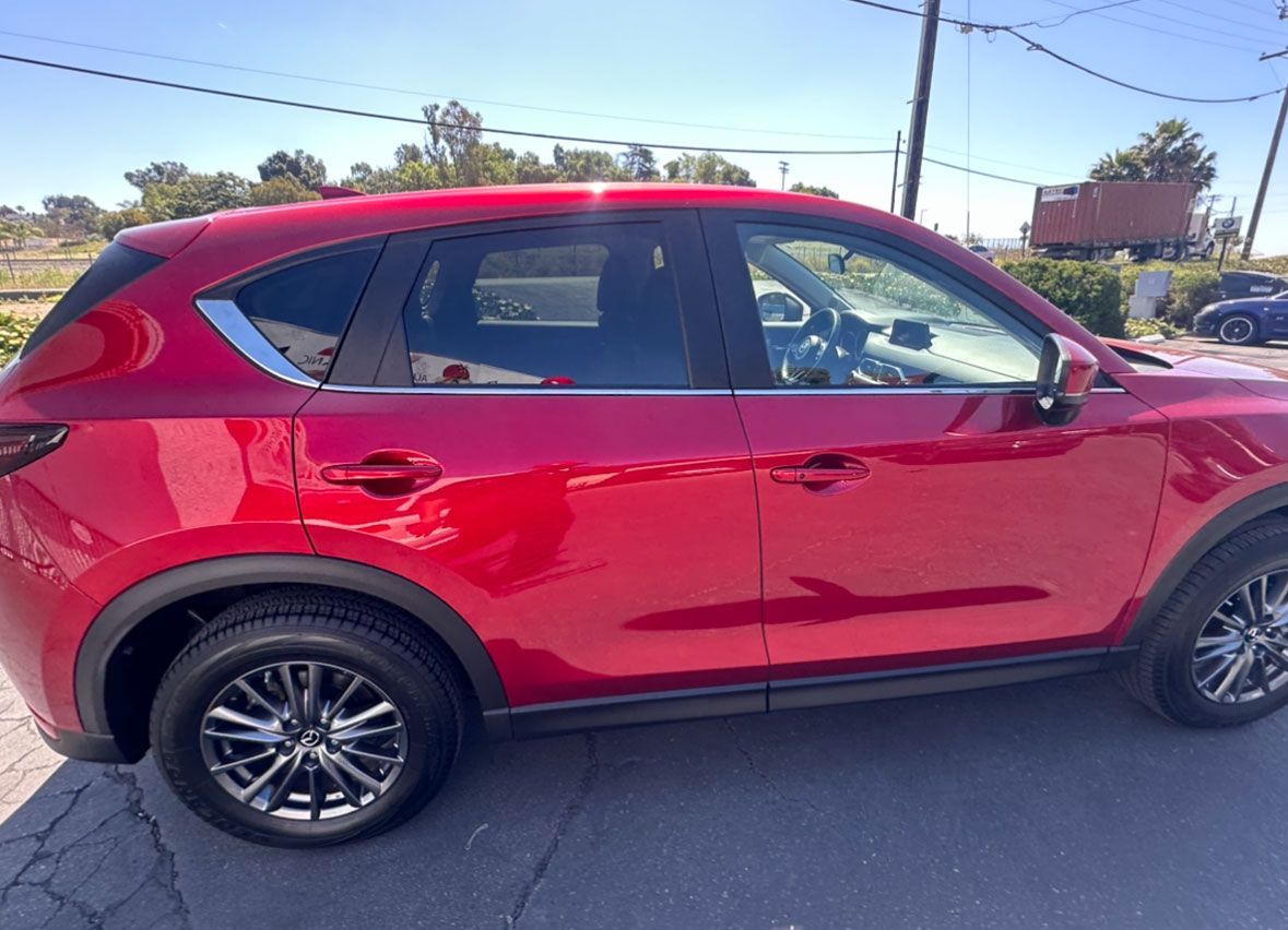 A red car is parked on the side of the road