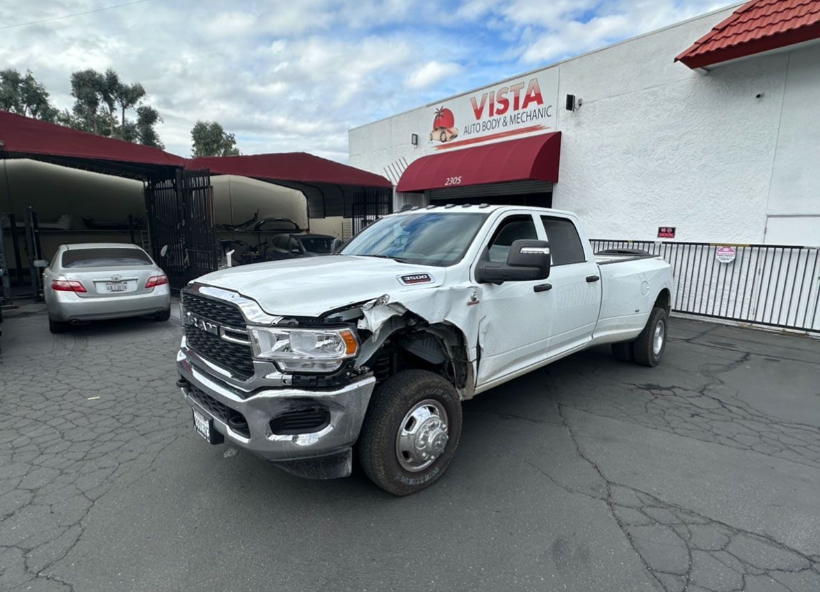 A white truck is parked in front of a building.