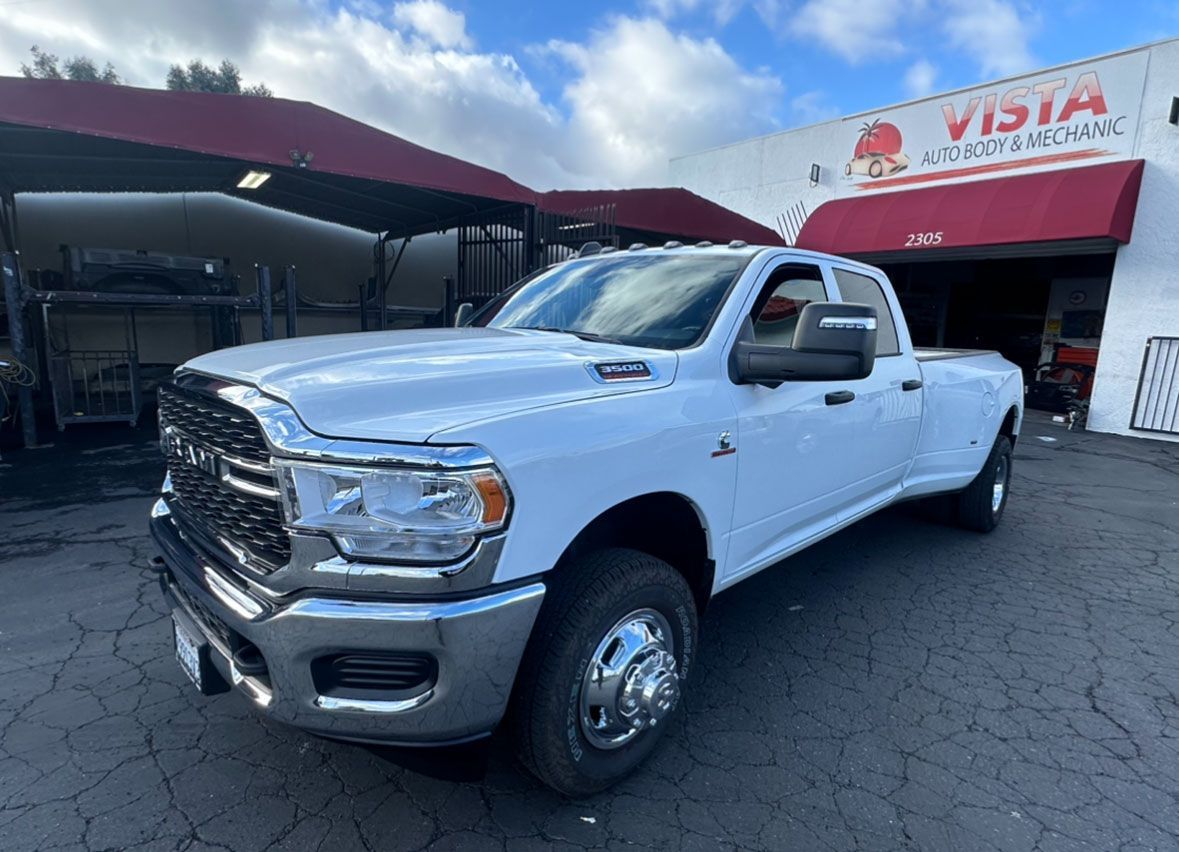A white truck is parked in front of a building.