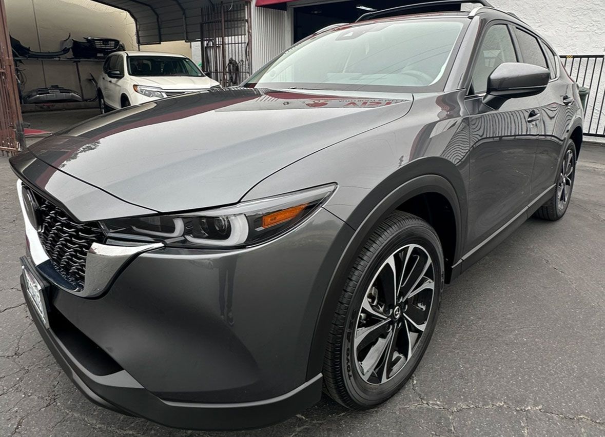 A mazda cx-30 is parked in a parking lot in front of a building.