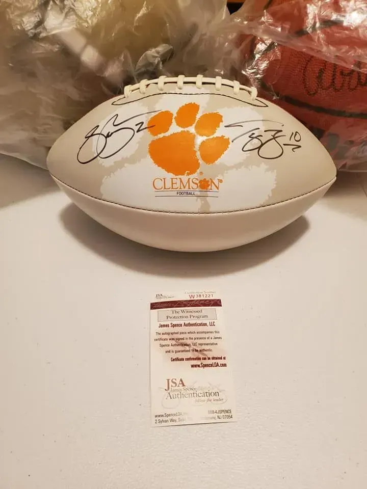 Clemson football memorabilia with orange paw logo and signatures, displayed on a table.
