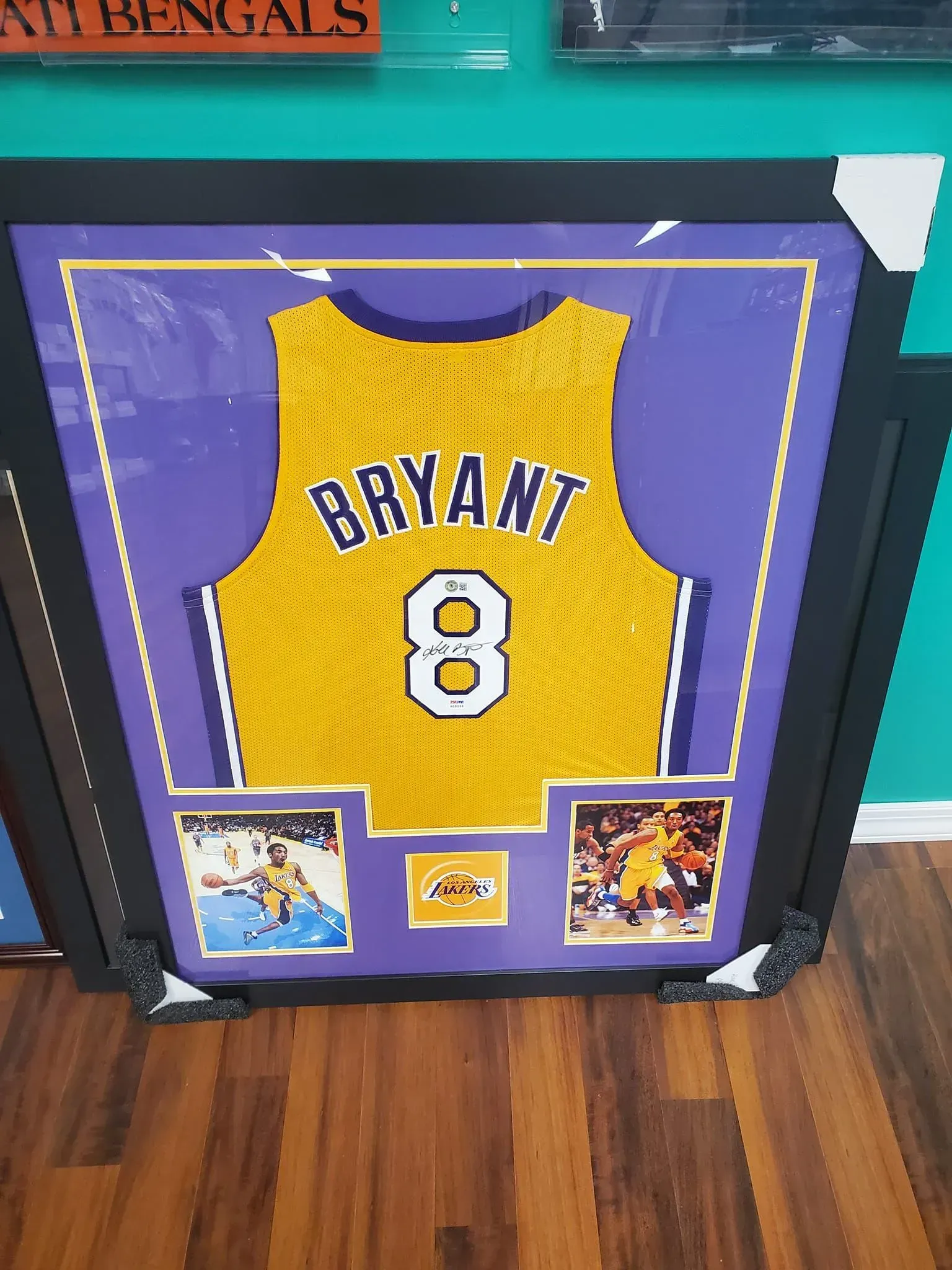 Framed purple and gold Kobe Bryant #8 Lakers jersey display on a wall