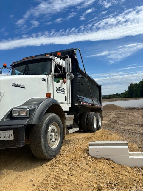 A dump truck is parked on a dirt road