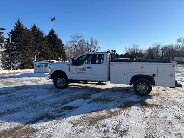 A white truck is parked in a snowy parking lot.