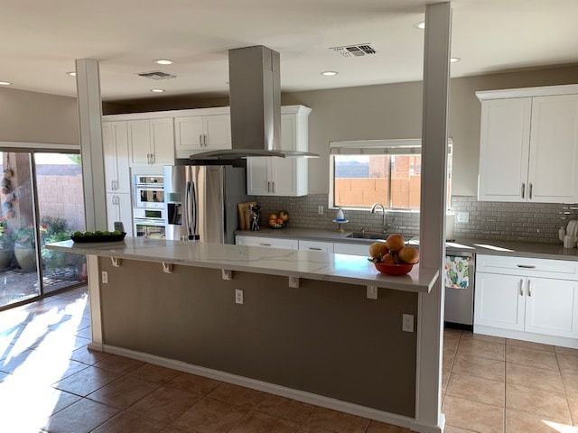 A kitchen with white cabinets and stainless steel appliances
