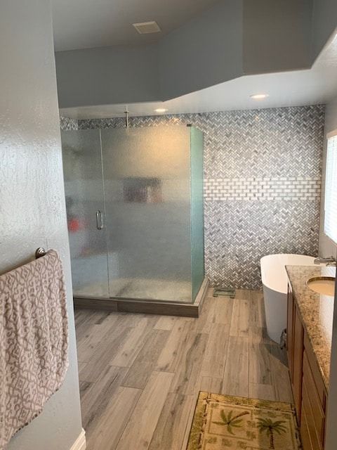 A bathroom with a tub , sink , shower and walk in shower.