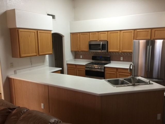 A kitchen with stainless steel appliances and wooden cabinets
