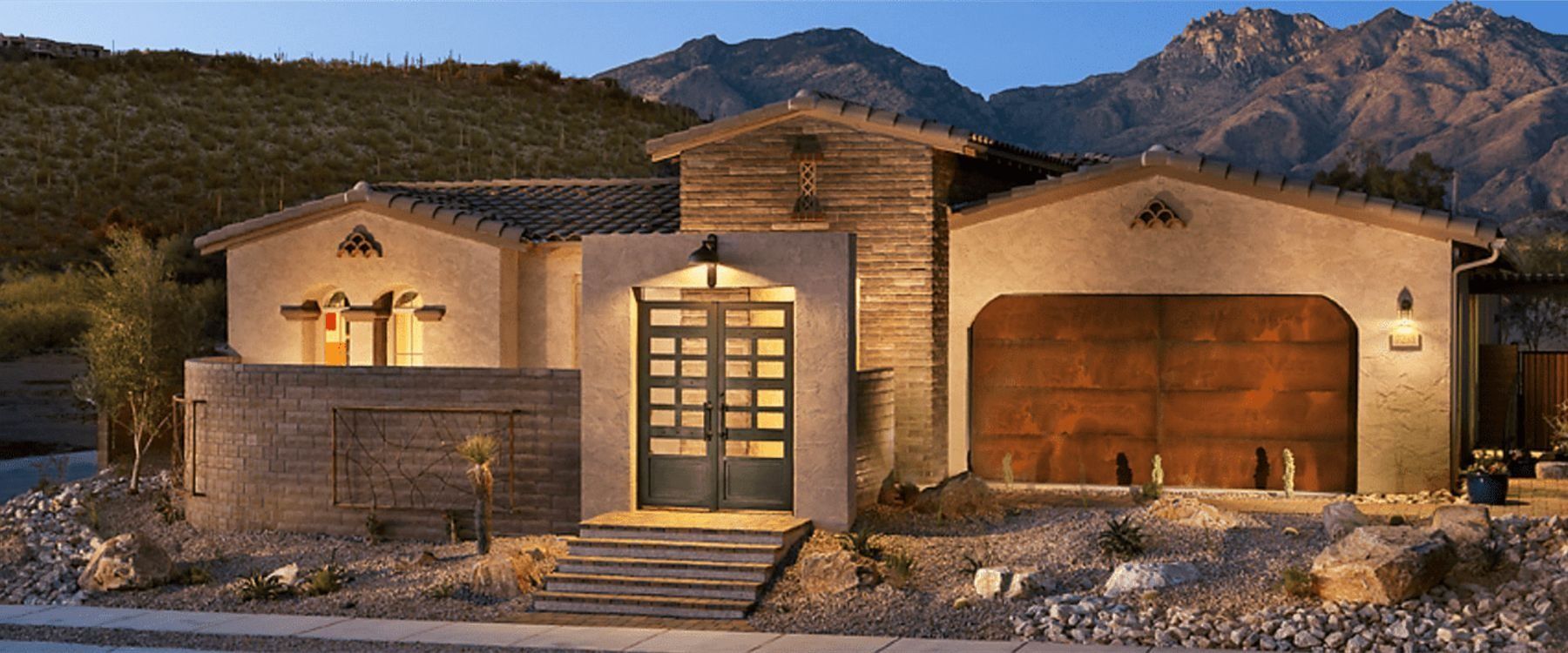 A house with a mountain in the background is lit up at night.