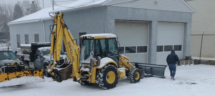 Backhoe with snow plow attachment