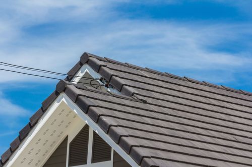 Gray tiled roof against a blue sky, with white trim.