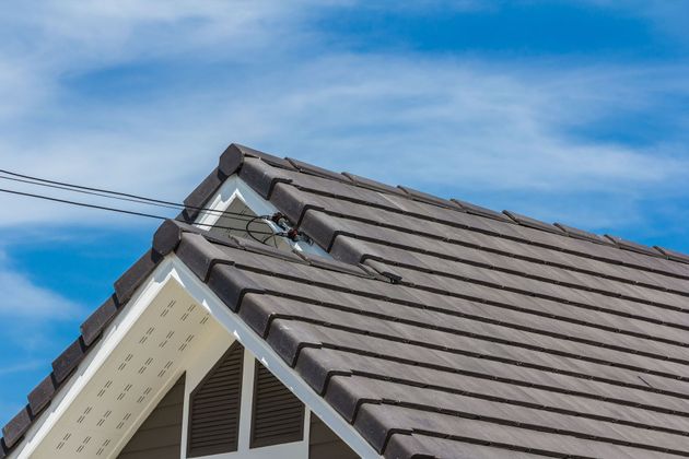 Gray tiled roof against a blue sky, with white trim.