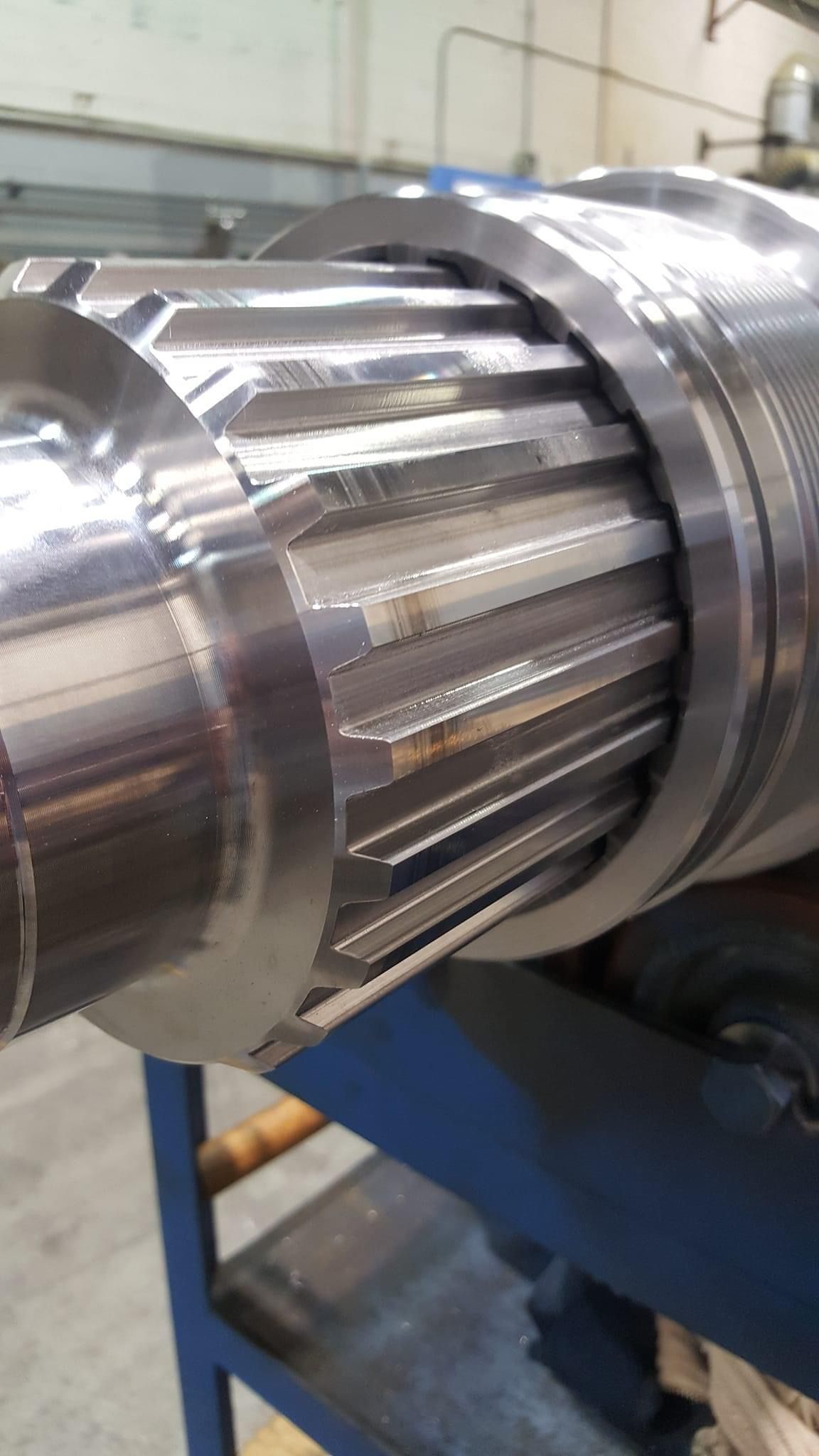 Metal shaft with detailed gear teeth and a smooth, reflective surface.