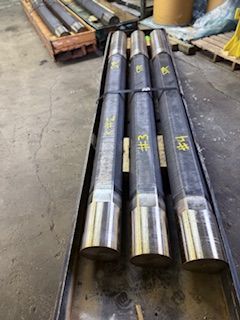 Metal cylinders bundled together, marked with numbers, likely industrial components.