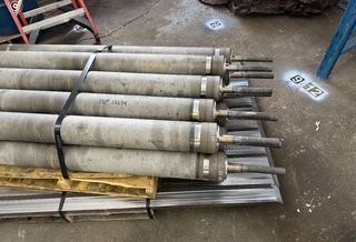Cylindrical industrial rollers stacked and strapped on a pallet.