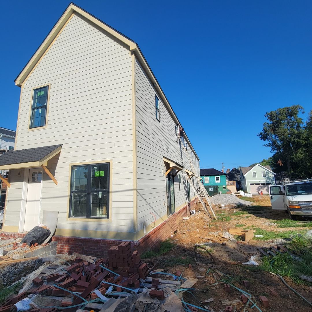 White brick townhomes under construction with black trim and windows. Sunny day.