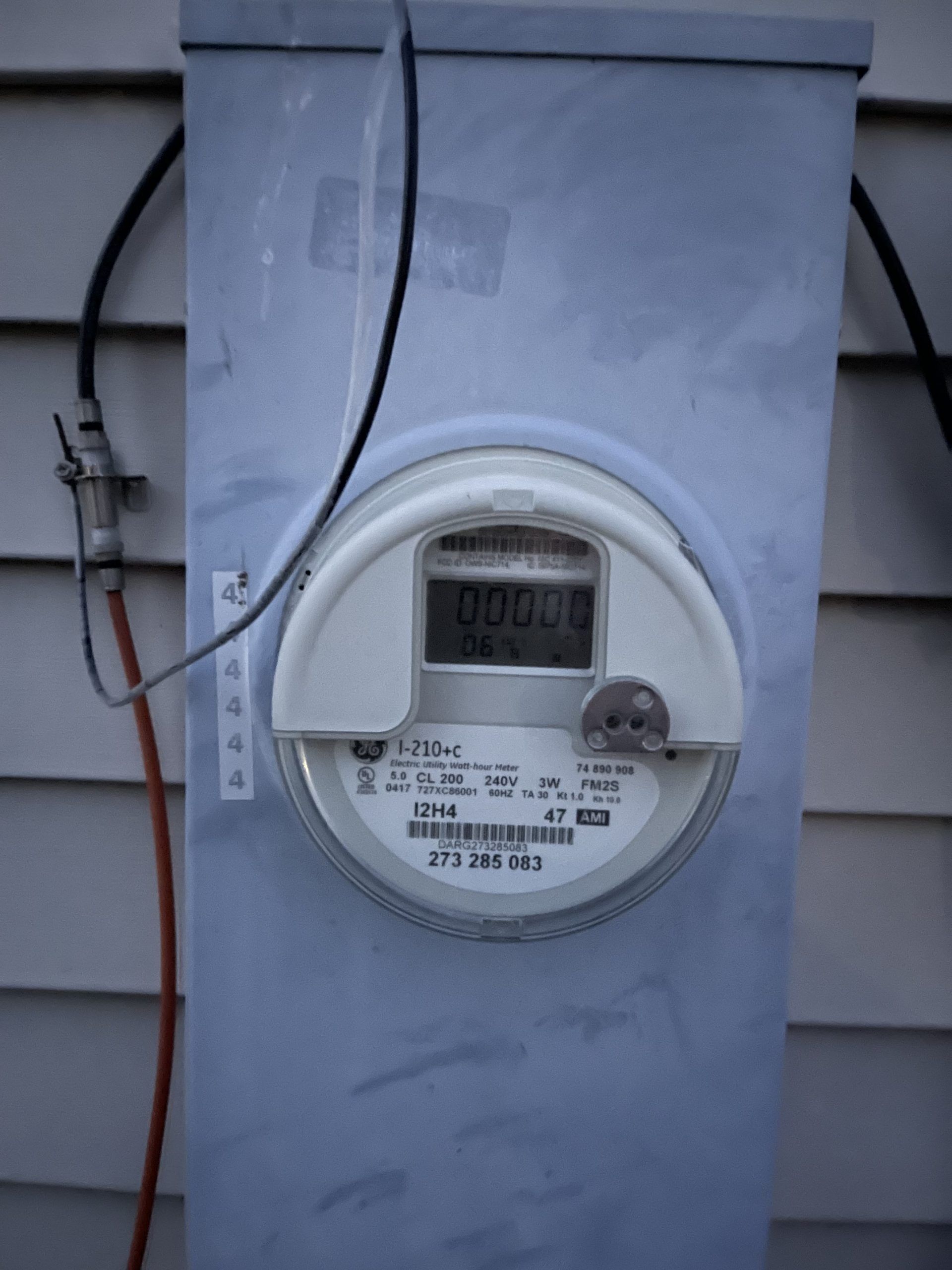 A meter on the side of a house has a digital display