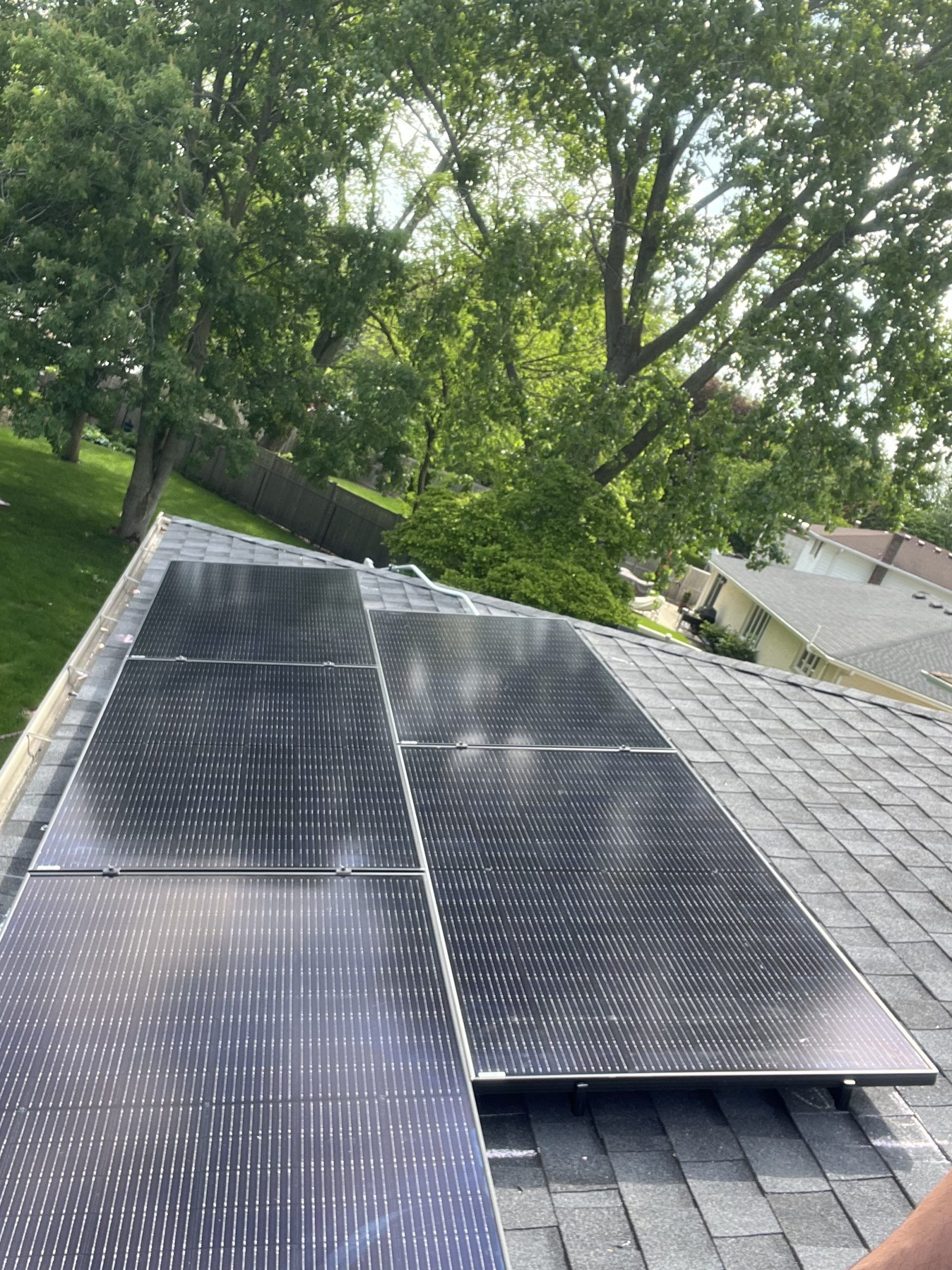 A person is installing solar panels on the roof of a house.