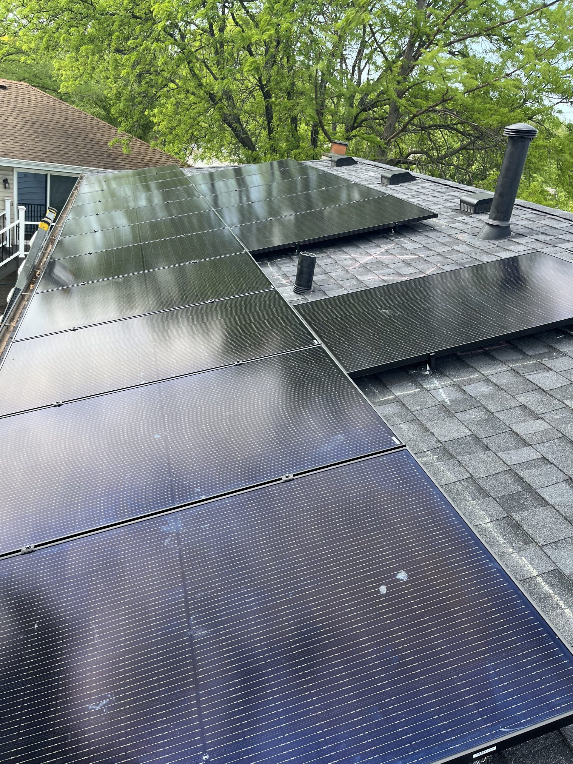 There are many solar panels on the roof of a house.