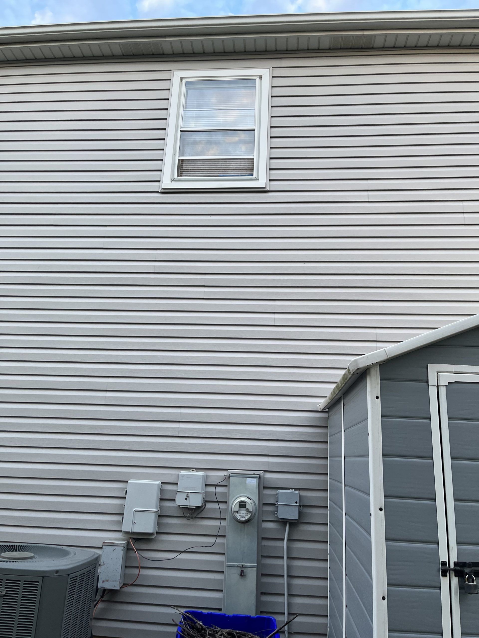 The back of a house with a shed and a window.
