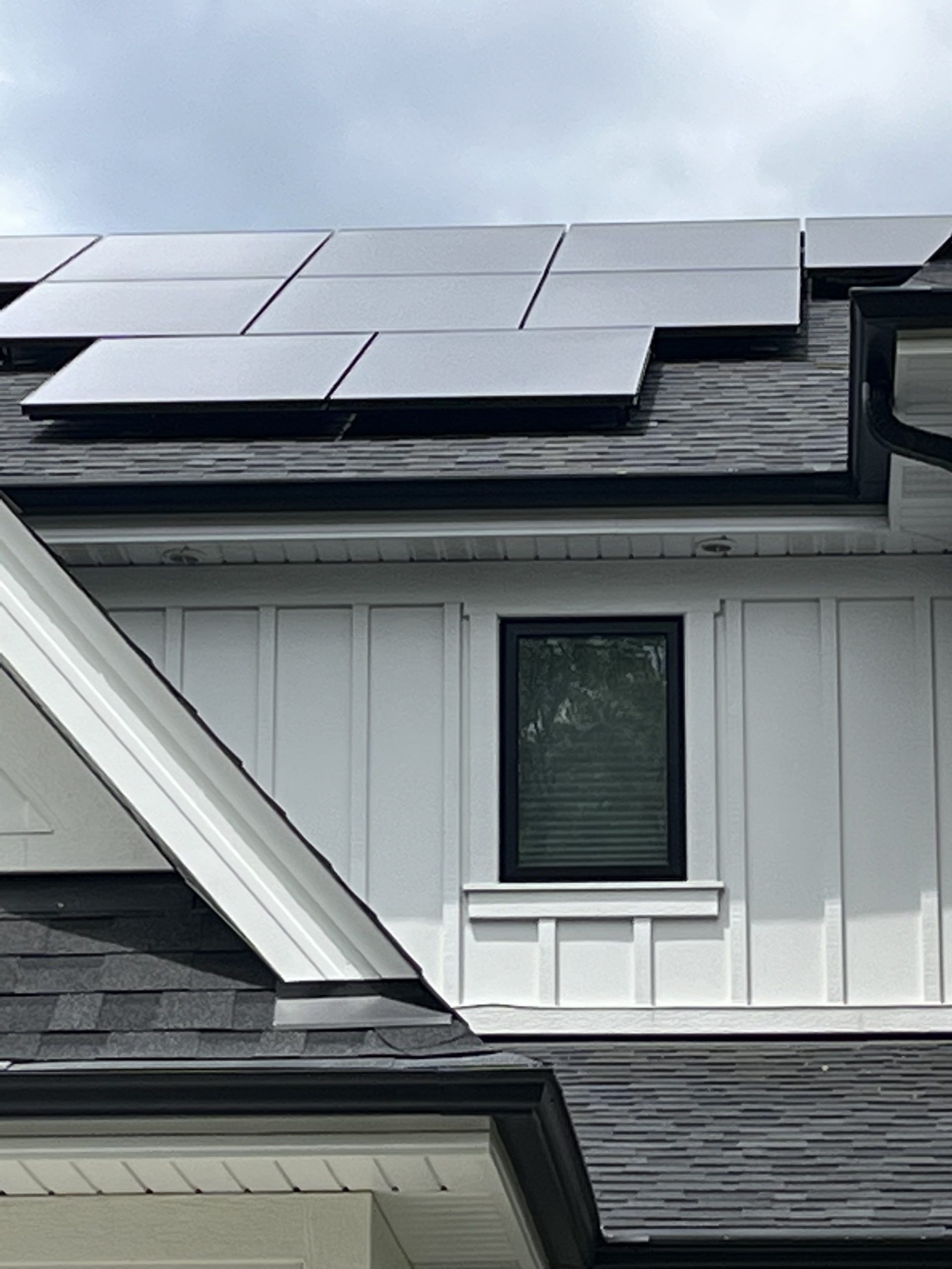 A house with solar panels on the roof and a window.