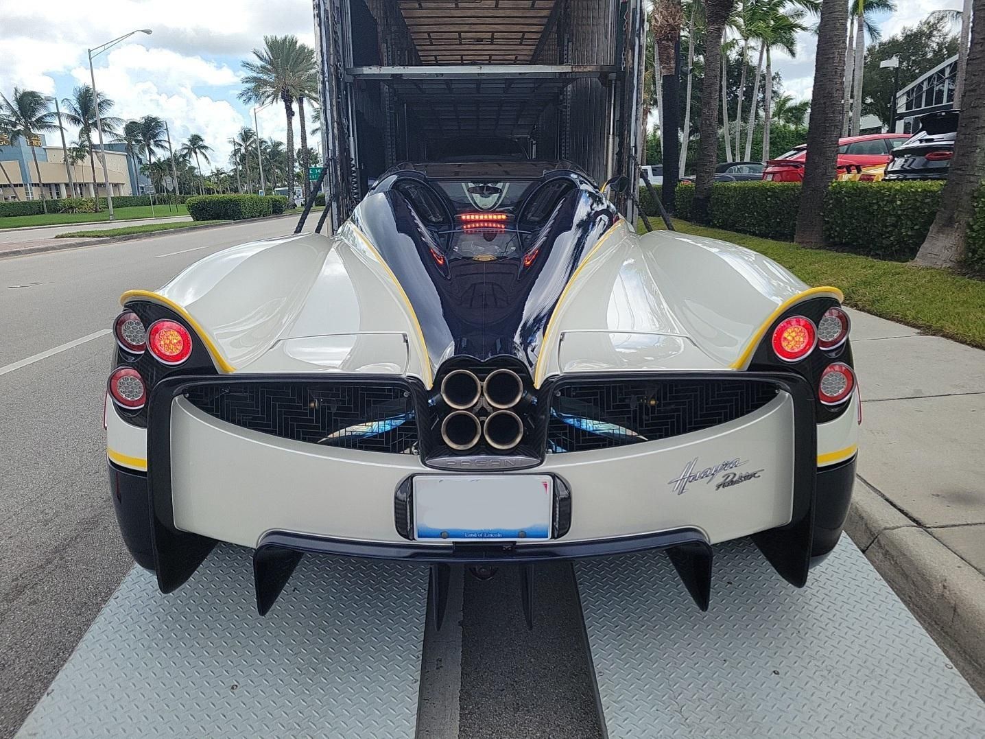 A white sports car is parked on the side of the road.