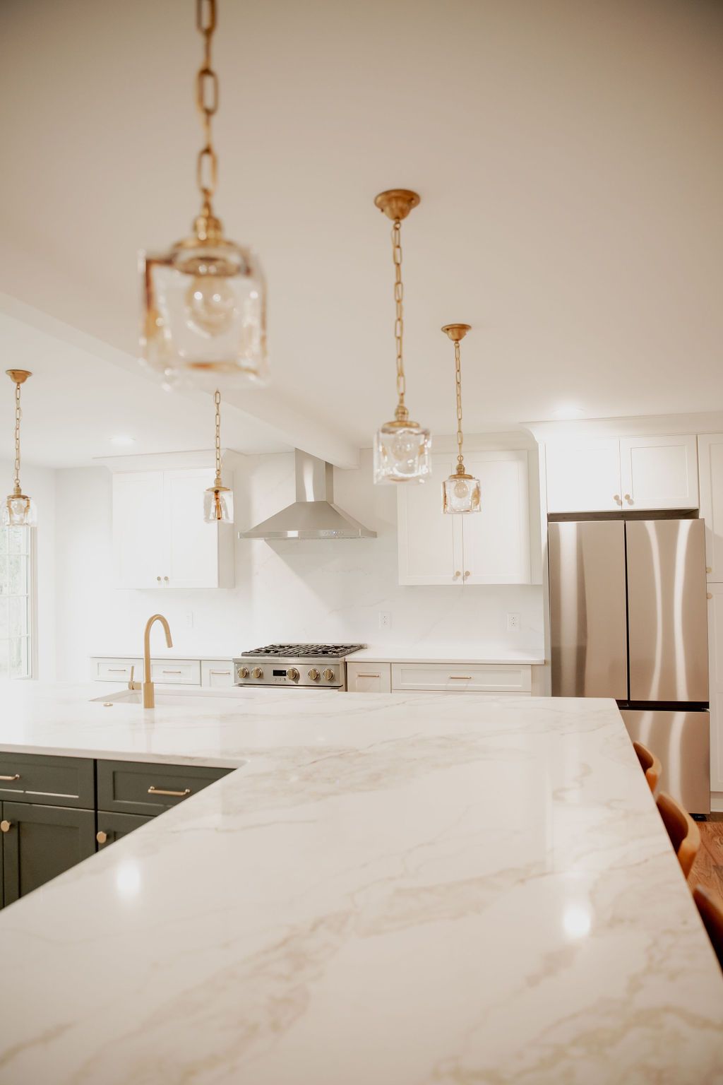 A kitchen with white cabinets and stainless steel appliances and a marble counter top.