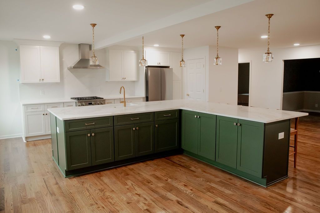 A kitchen with green cabinets and white cabinets and a large island.