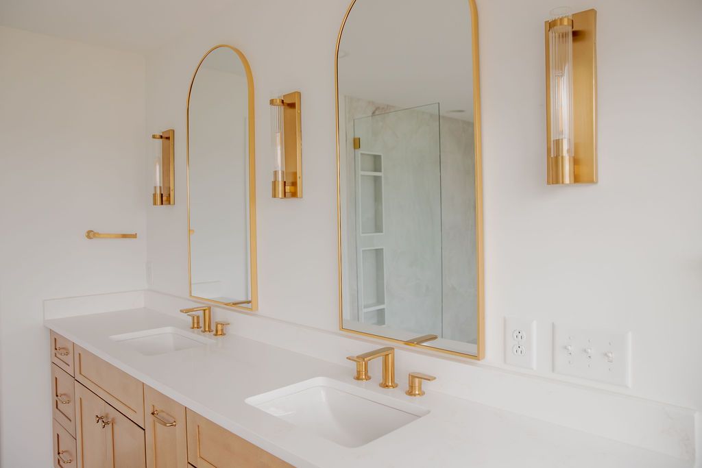 A bathroom with two sinks and two mirrors.