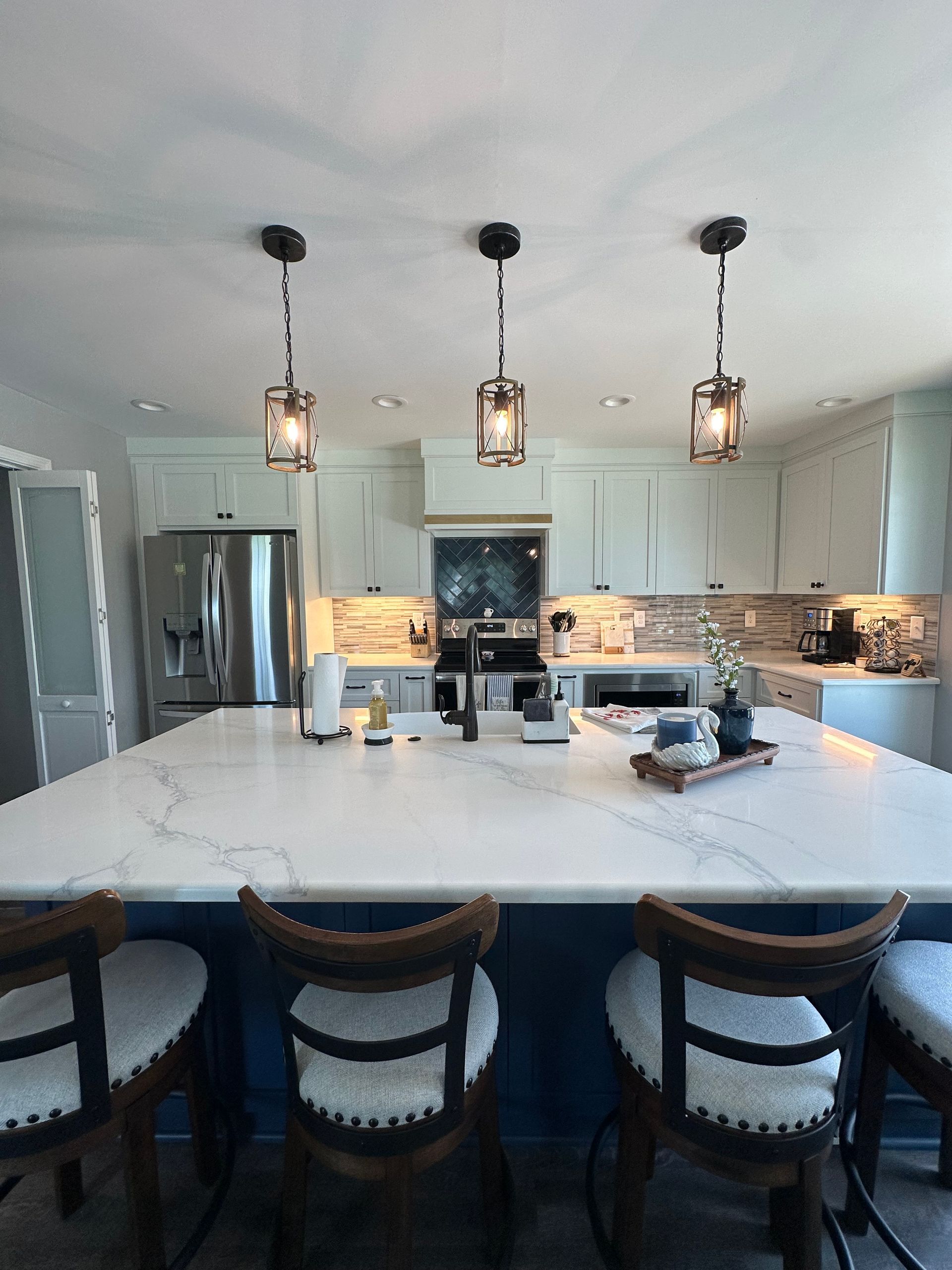 A kitchen with a large island and stools
