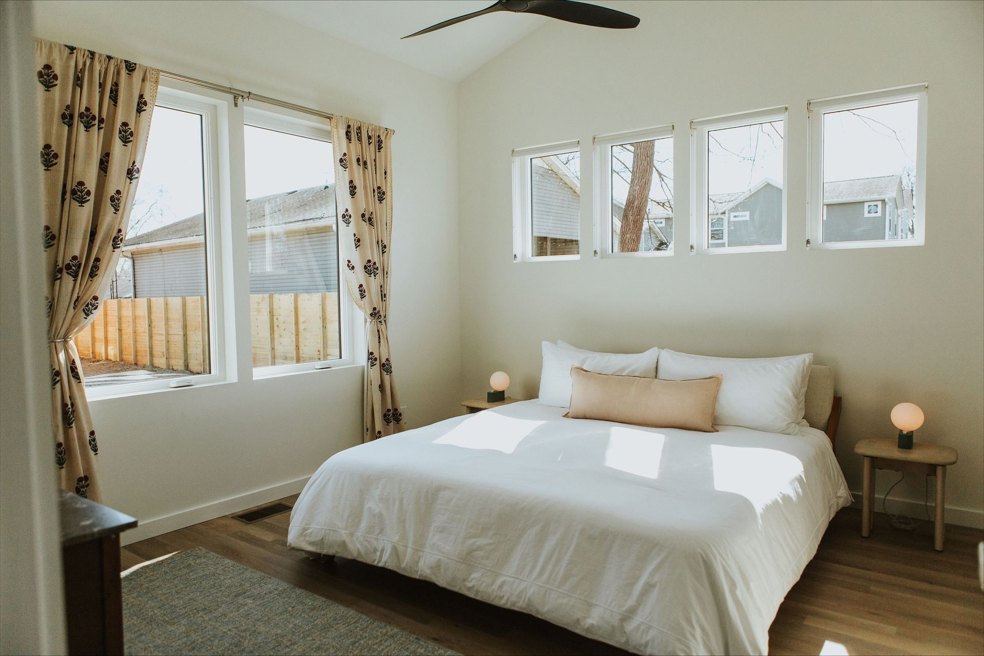 A bedroom with a king size bed and a ceiling fan.
