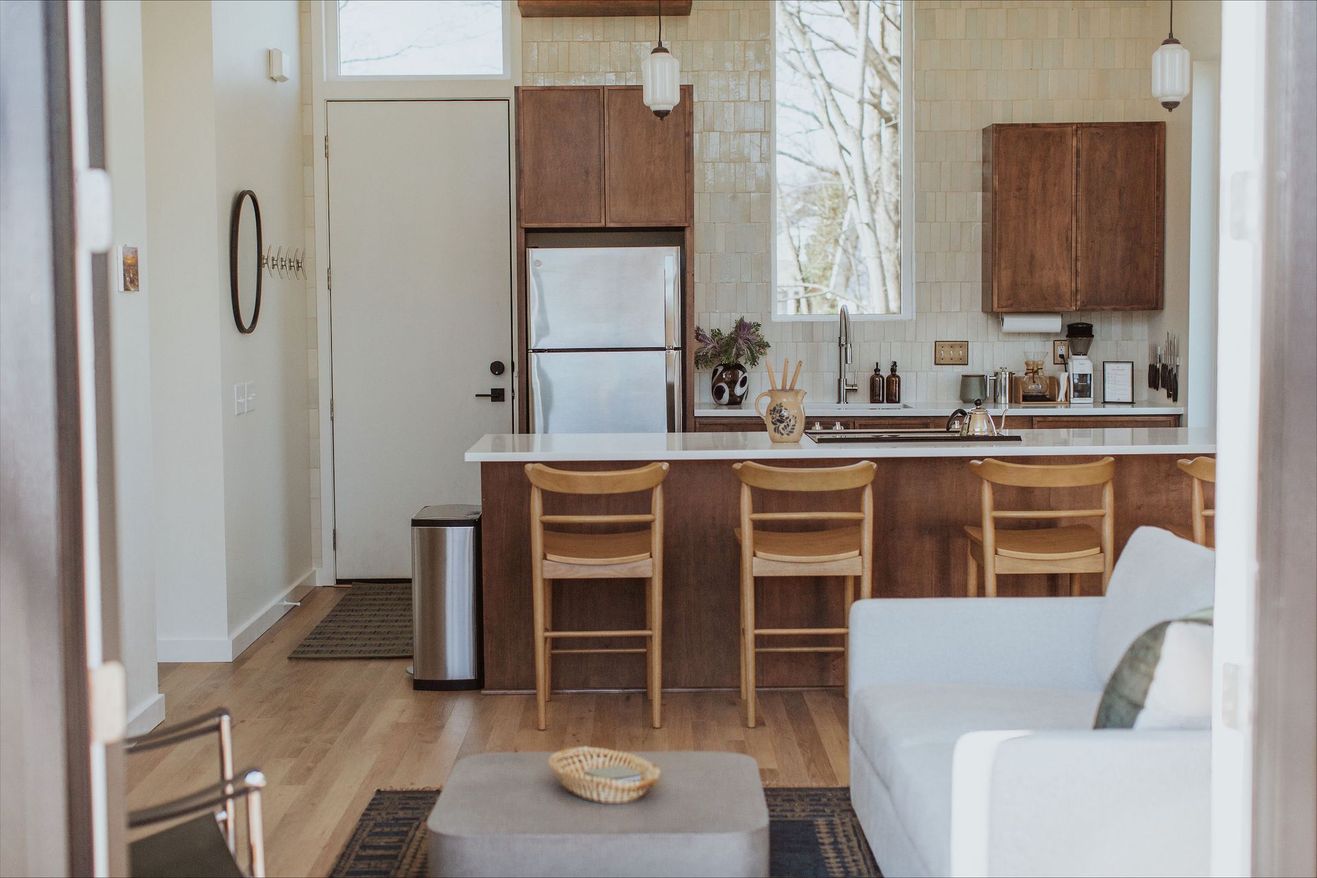 A living room filled with furniture and a kitchen with a refrigerator.