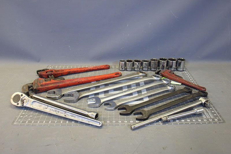 A collection of wrenches and sockets on a checkered surface, ready for use.