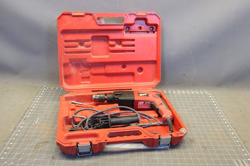 Red power drill in an open red carrying case.