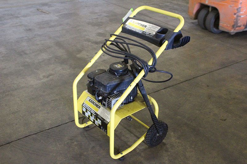 Yellow Karcher gas pressure washer on a concrete floor with one black wheel.