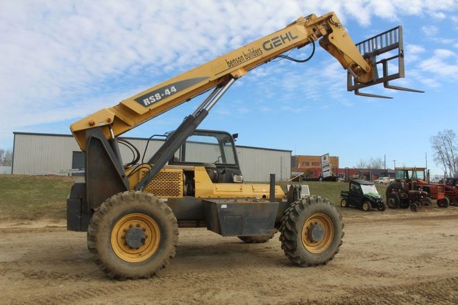 Yellow Gehl RS6-41 telehandler with raised forks, outdoors.