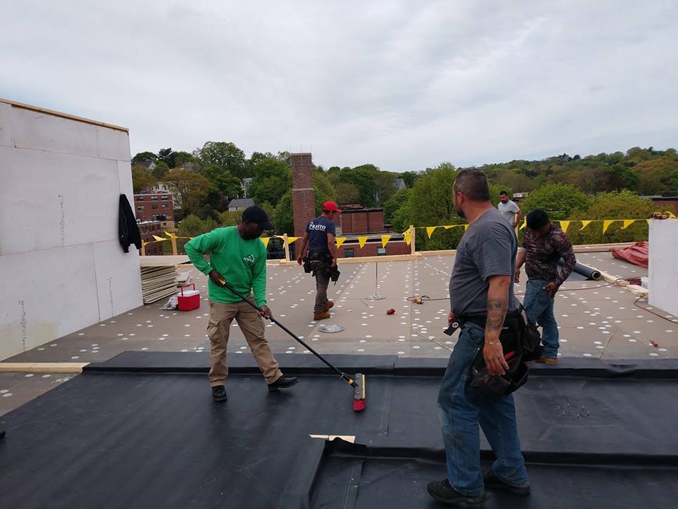 Kyne Roofing & Construction people waterproof coating on roof