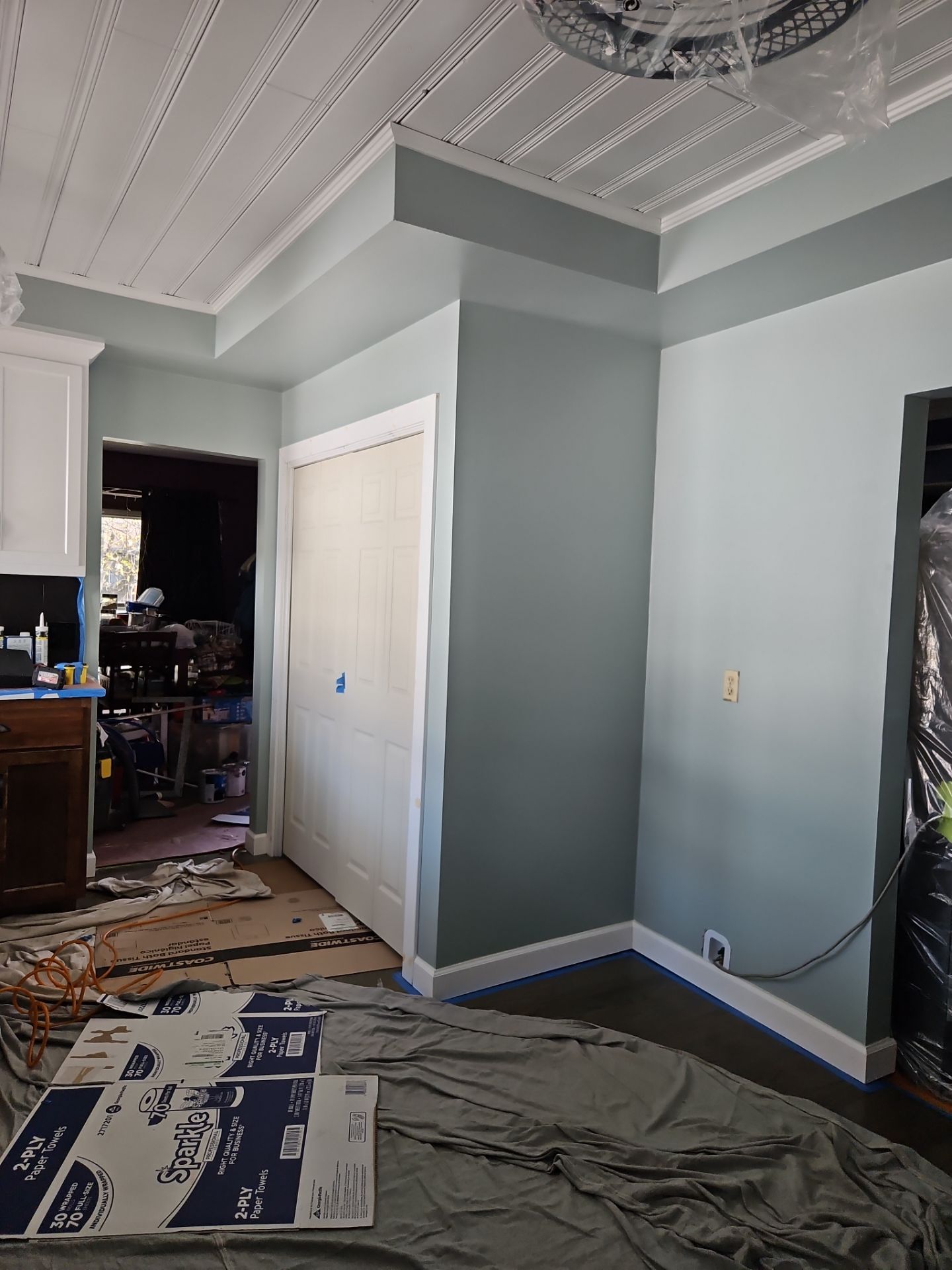 Room with new paint job; teal walls, white trim, textured ceiling, closet and open doorway.