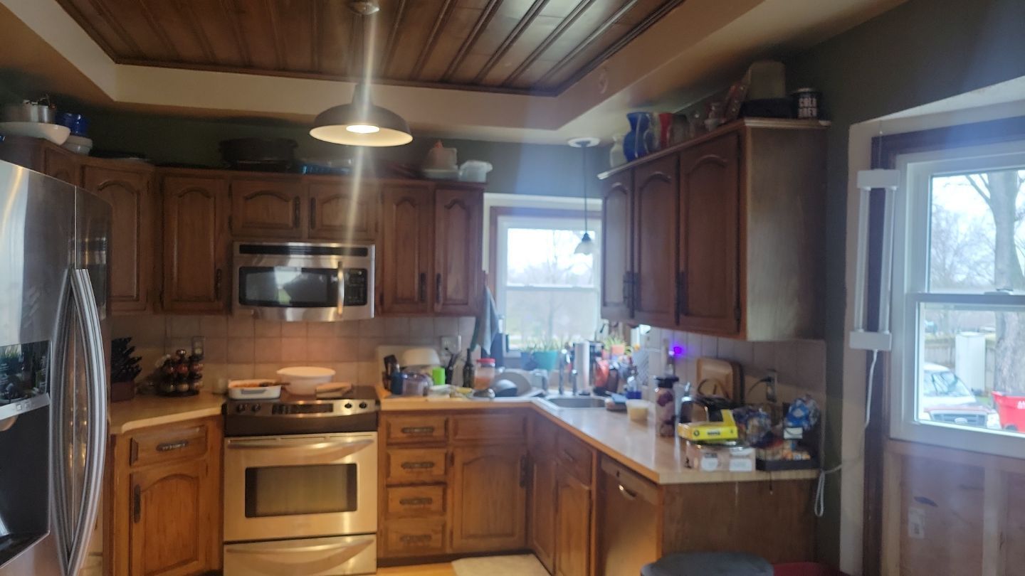 Kitchen with wooden cabinets, stainless steel appliances, and a window.