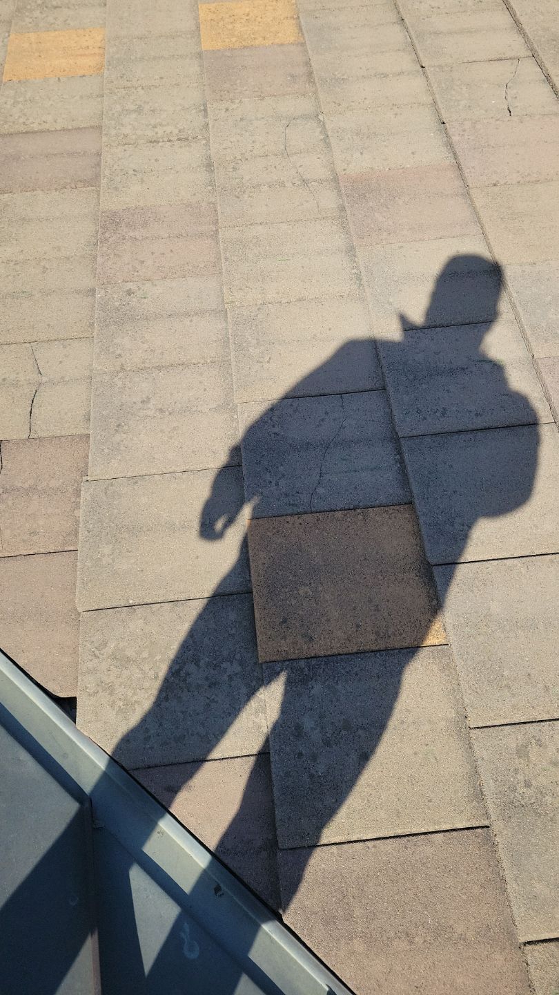 Shadow of a person on a tiled surface, arm extended. Sunny day.