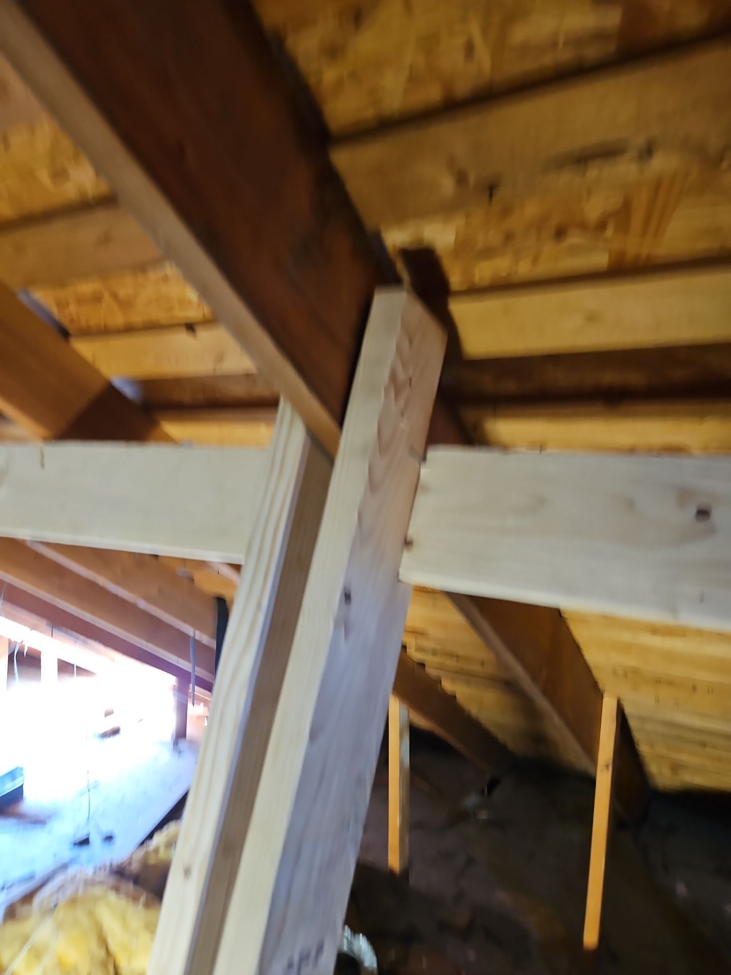 Wooden attic rafters and support beam.