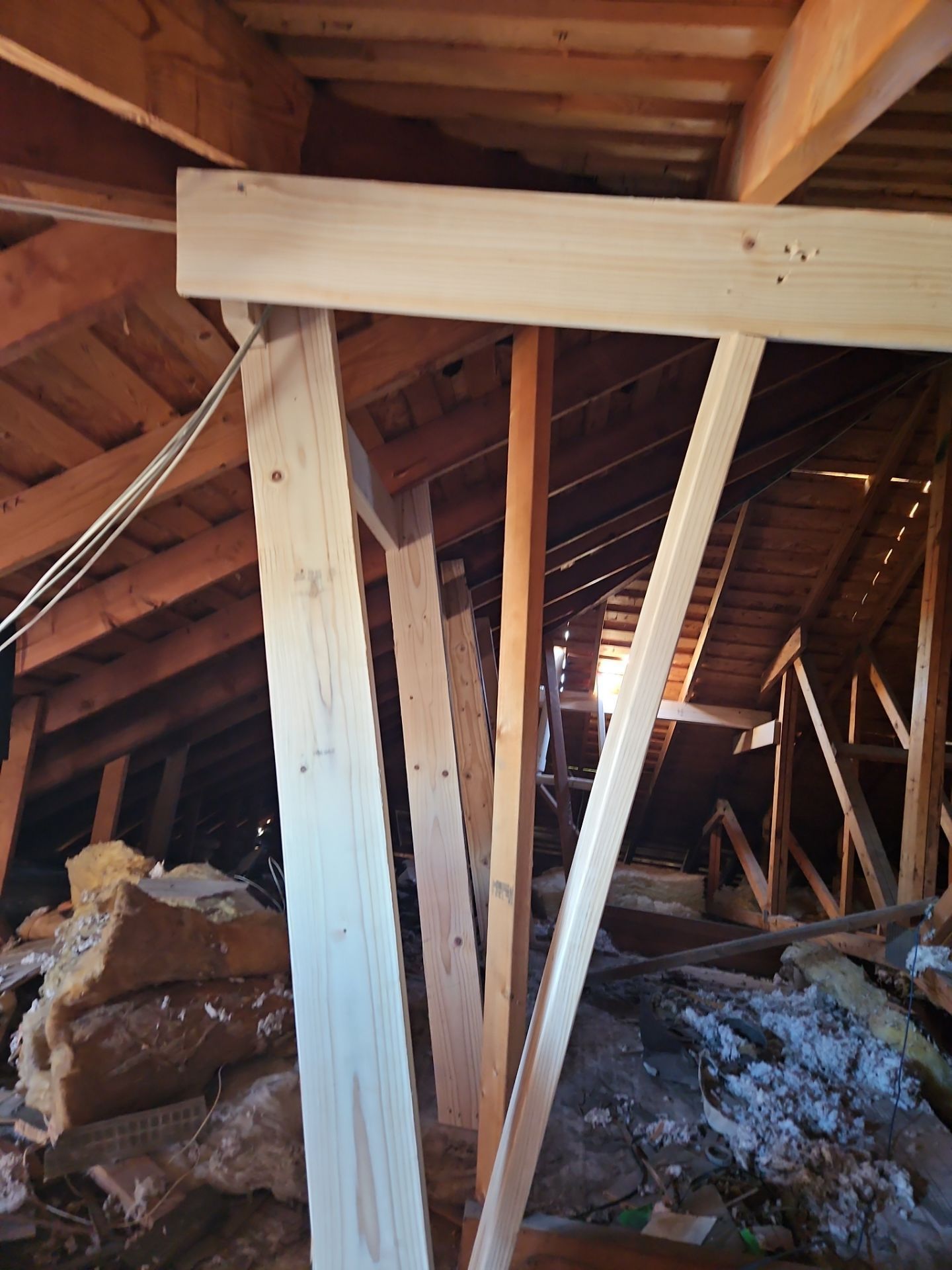 Wooden attic structure with supporting beams and rafters.