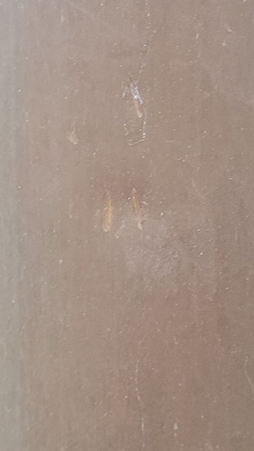 Brown, textured surface with light scratches and marks.