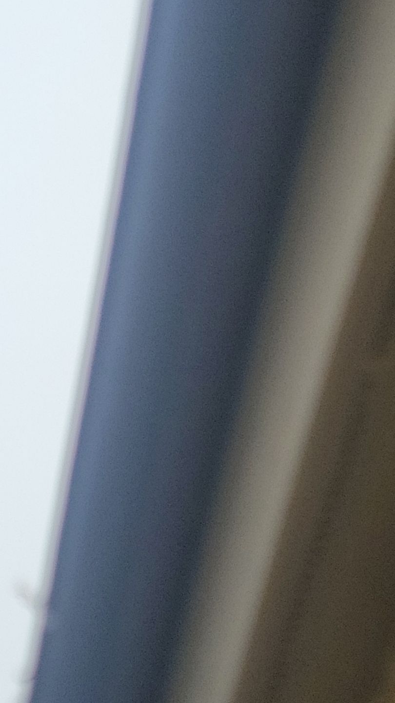 Diagonal view of a dark blue surface next to a light tan surface, possibly a door frame or similar.